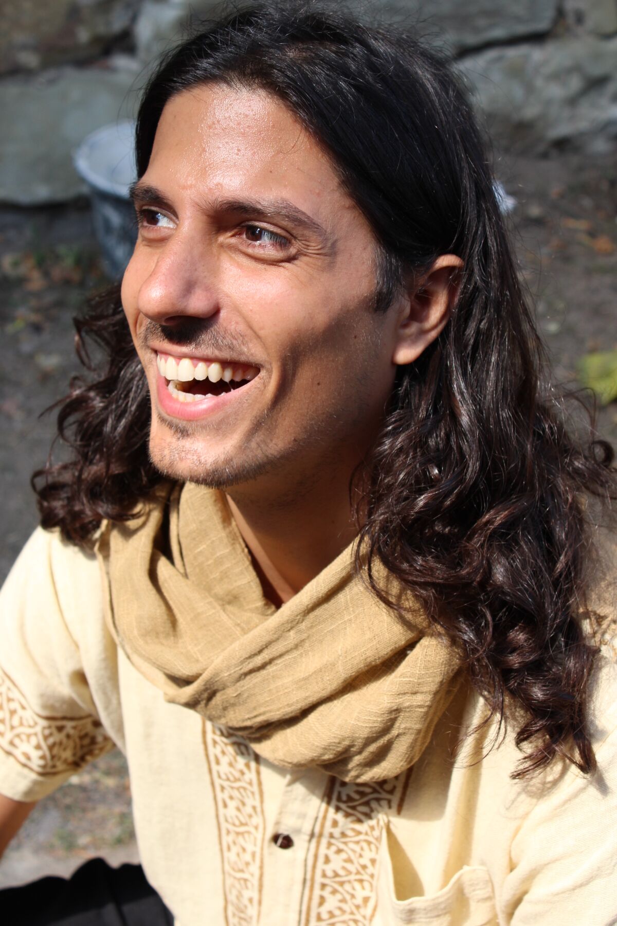 Itay Spiegel laughing, in a cream shirt and scarf